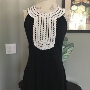 Sleeveless black dress with white embroidery
